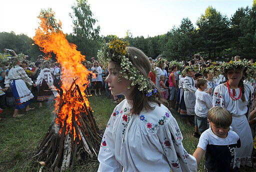 Ukrainians wearing traditional clothing dance at a campfire while celebrating Ivan Kupala Night, a traditional Slavic holiday not far from Kiev on July 6, 2009. During the celebration, originating in pagan times, people put wreaths of flowers over their head, jump over fires, and swim naked. AFP PHOTO/ SERGEI SUPINSKY